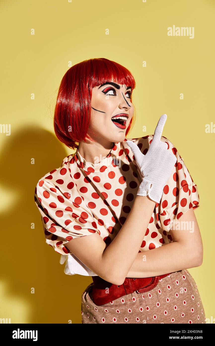 Una splendida rossa in un abito a pois si distingue su uno sfondo giallo vibrante, trasudando l'atmosfera di un personaggio dei fumetti. Foto Stock