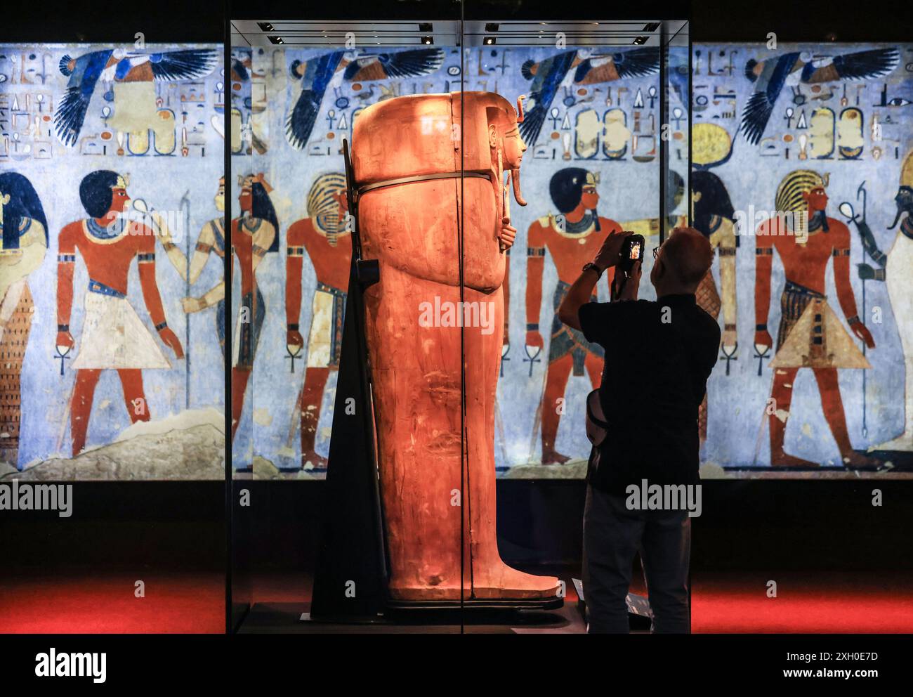 Colonia, Germania. 11 luglio 2024. Un uomo fotografa il sarcofago di Ramsete II nell'Odisseo. La mostra "Ramses & the Gold of the Pharaohs" è visibile a Colonia dal 13 giugno 2024. Il fulcro è il vero sarcofago di Ramsete II. Tutti gli oggetti provengono da musei e siti storici in Egitto. Crediti: Oliver Berg/dpa/Alamy Live News Foto Stock