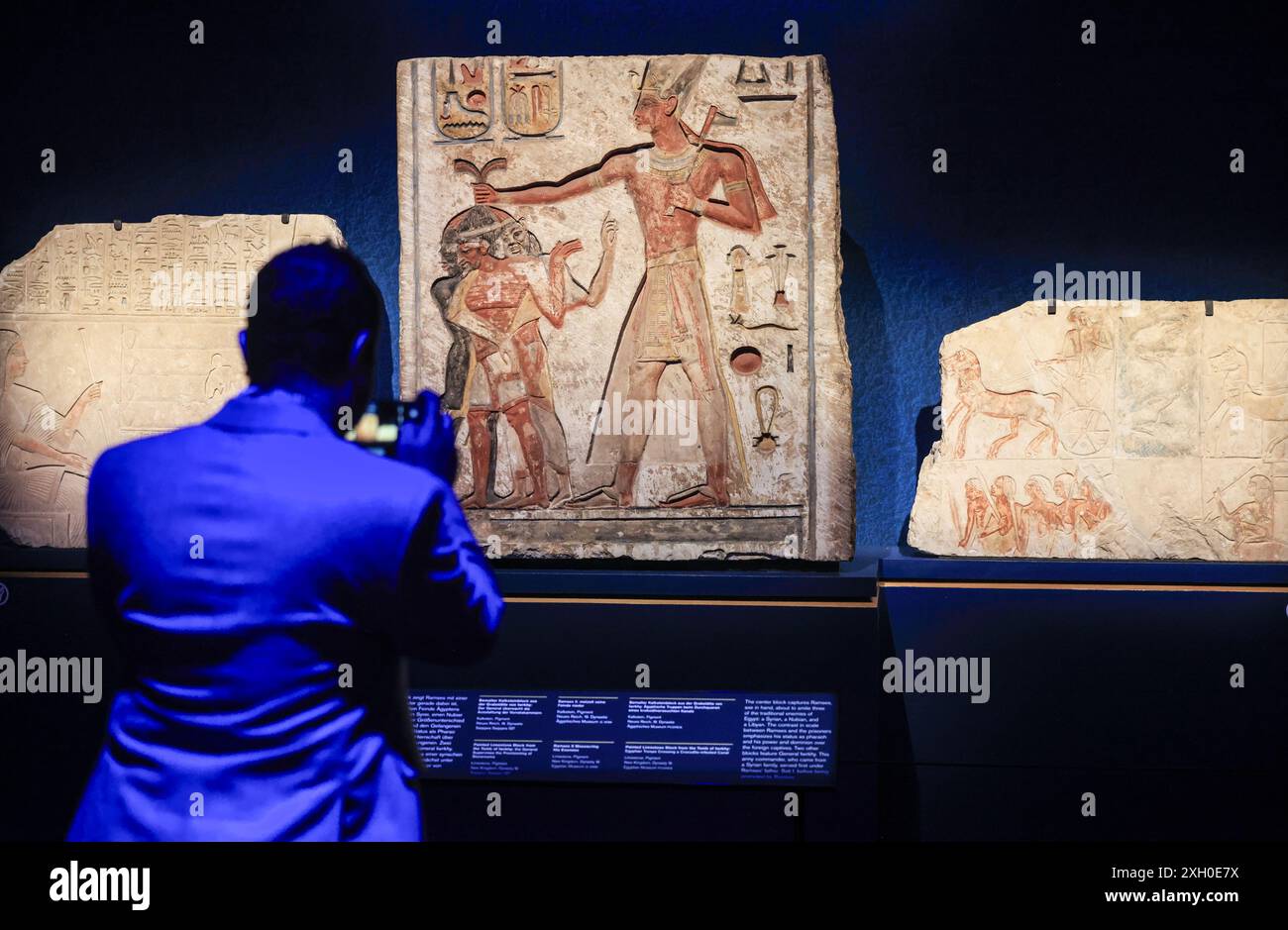 Colonia, Germania. 11 luglio 2024. Un uomo fotografa blocchi di pietra calcarea dipinti da una tomba nell'Odisseo. La mostra "Ramses & the Gold of the Pharaohs" è visibile a Colonia dal 13 giugno 2024. Il fulcro è il vero sarcofago di Ramsete II. Tutti gli oggetti provengono da musei e siti storici in Egitto. Crediti: Oliver Berg/dpa/Alamy Live News Foto Stock