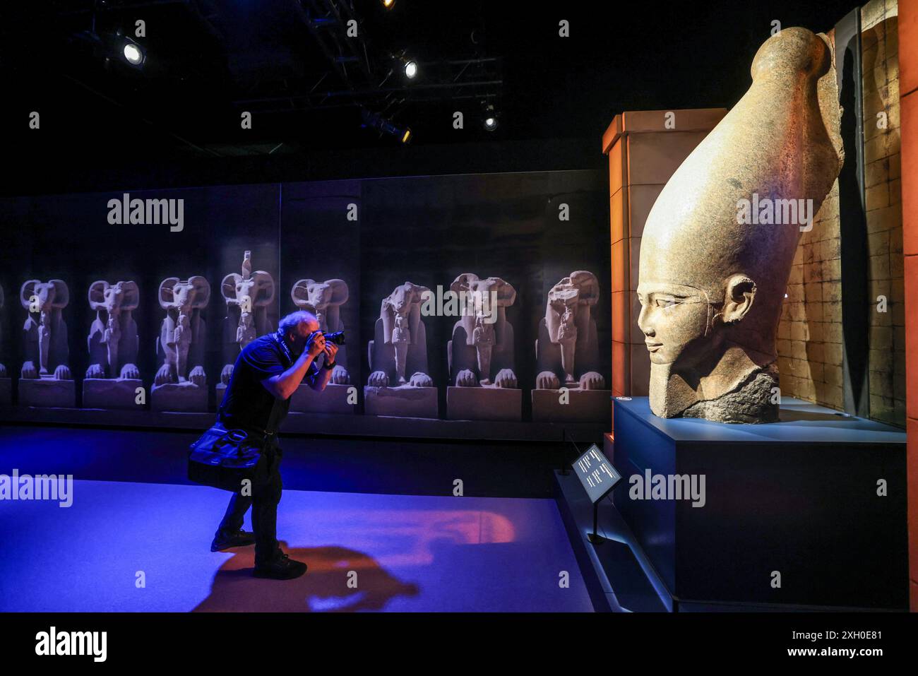 Colonia, Germania. 11 luglio 2024. Un uomo fotografa una statua collossale di Ramsete II nell'Odisseo. La mostra "Ramses & the Gold of the Pharaohs" è visibile a Colonia dal 13 giugno 2024. Il fulcro è il vero sarcofago di Ramsete II. Tutti gli oggetti provengono da musei e siti storici in Egitto. Crediti: Oliver Berg/dpa/Alamy Live News Foto Stock