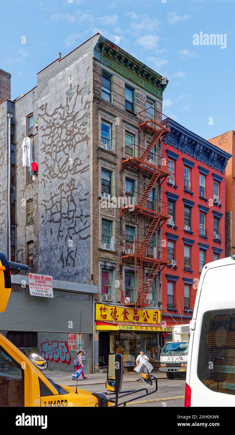NYC Chinatown: Un tipico edificio di appartamenti in mattoni e terracotta sopra un negozio con cartello cinese, in una tranquilla mattinata nei giorni feriali. Foto Stock