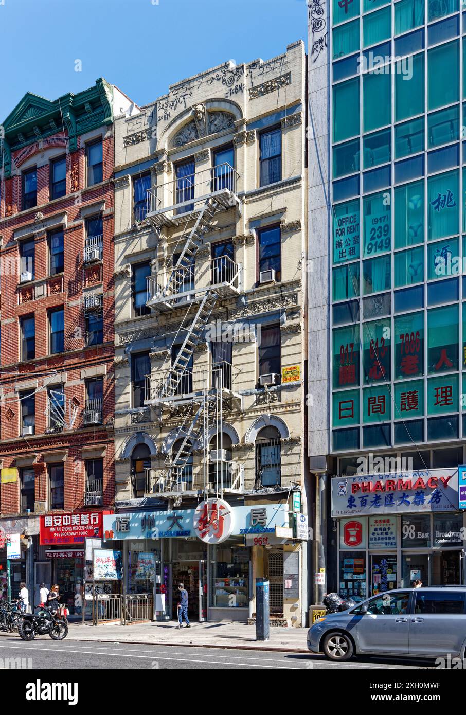 NYC Chinatown: Un tipico edificio di appartamenti in mattoni e terracotta sopra un negozio con cartello cinese, in una tranquilla mattinata nei giorni feriali. Foto Stock