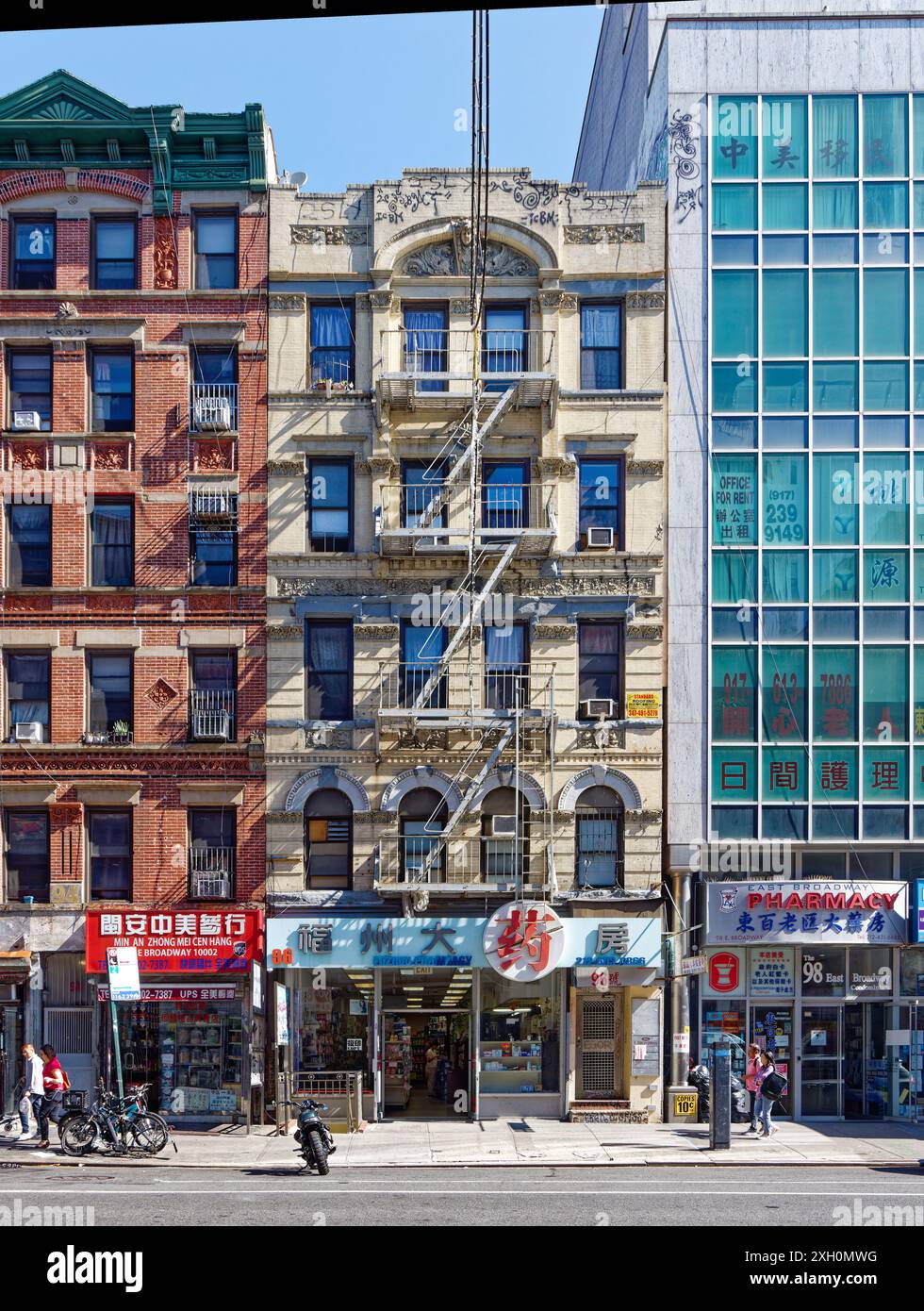 NYC Chinatown: Un tipico edificio di appartamenti in mattoni e terracotta sopra un negozio con cartello cinese, in una tranquilla mattinata nei giorni feriali. Foto Stock