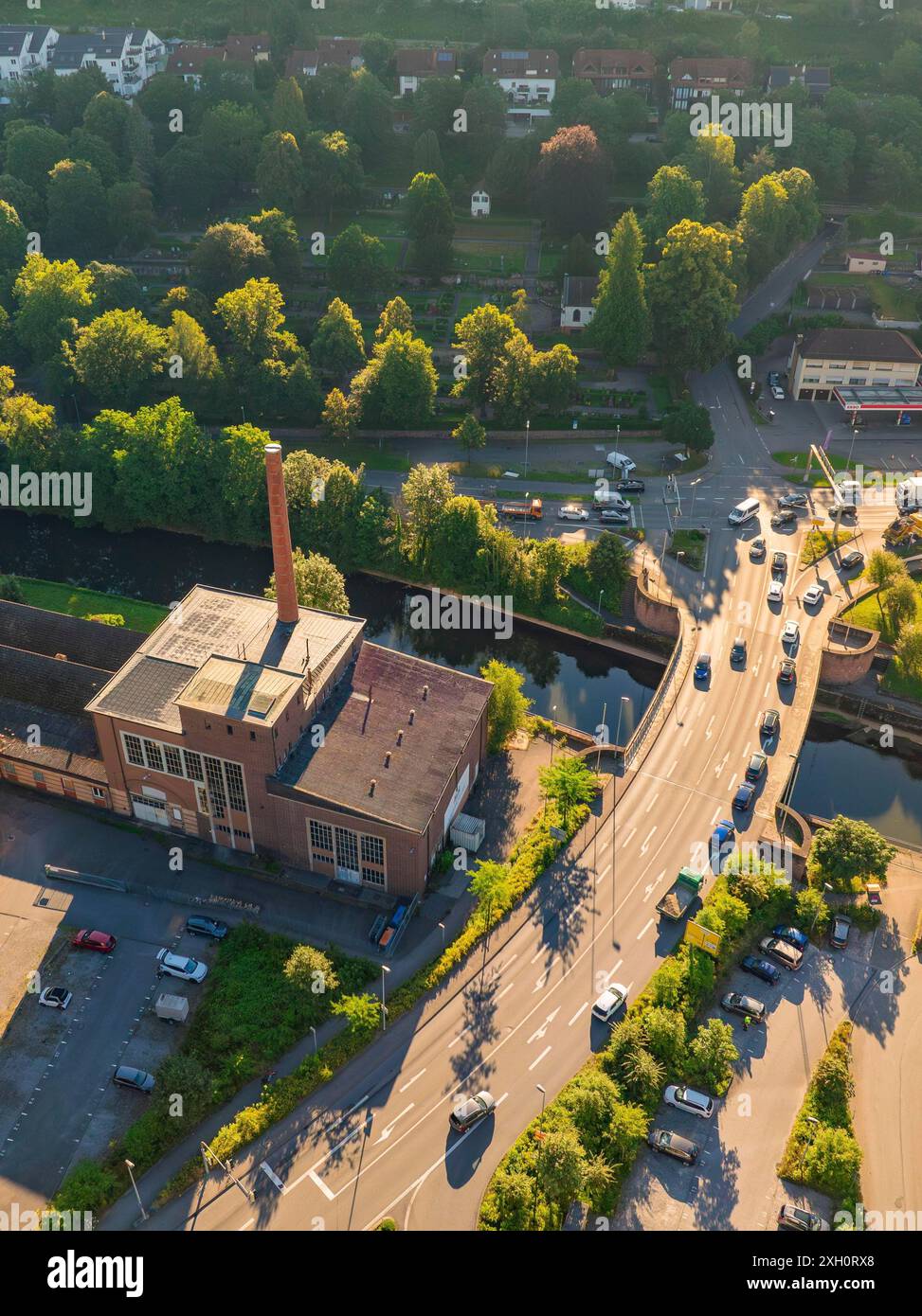 Vista aerea di un edificio industriale con camino, vicino a una strada e auto, vicino a un fiume e circondato dalla natura, Calw, Foresta Nera, Germania Foto Stock
