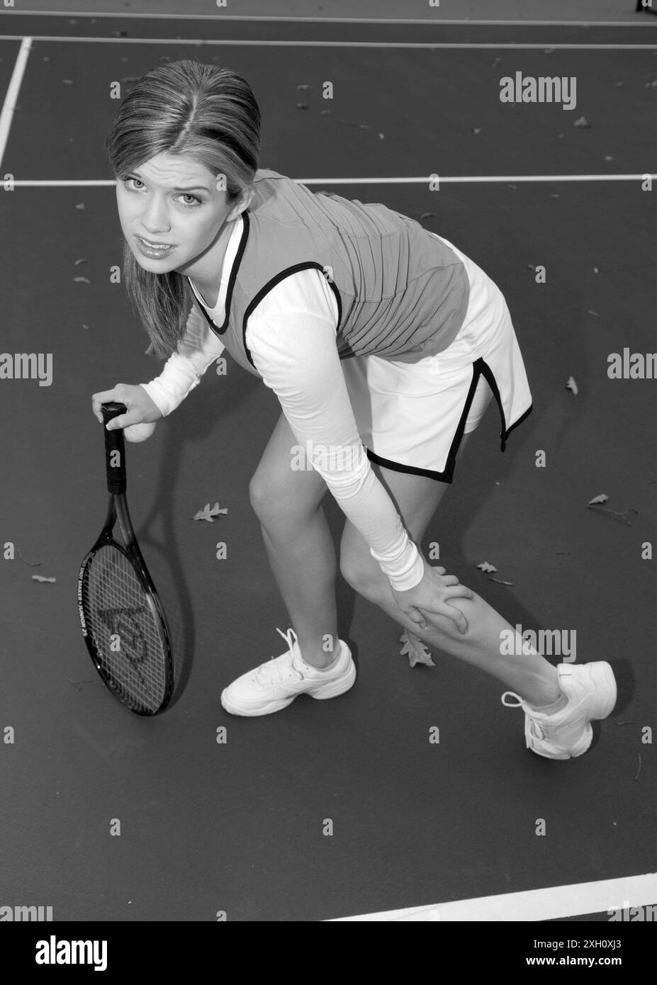Tennista caucasica tennista adolescente che tiene una gamba con un cavallo charley e tiene una racchetta da tennis e una palla con l'altra mano. STATI UNITI Foto Stock