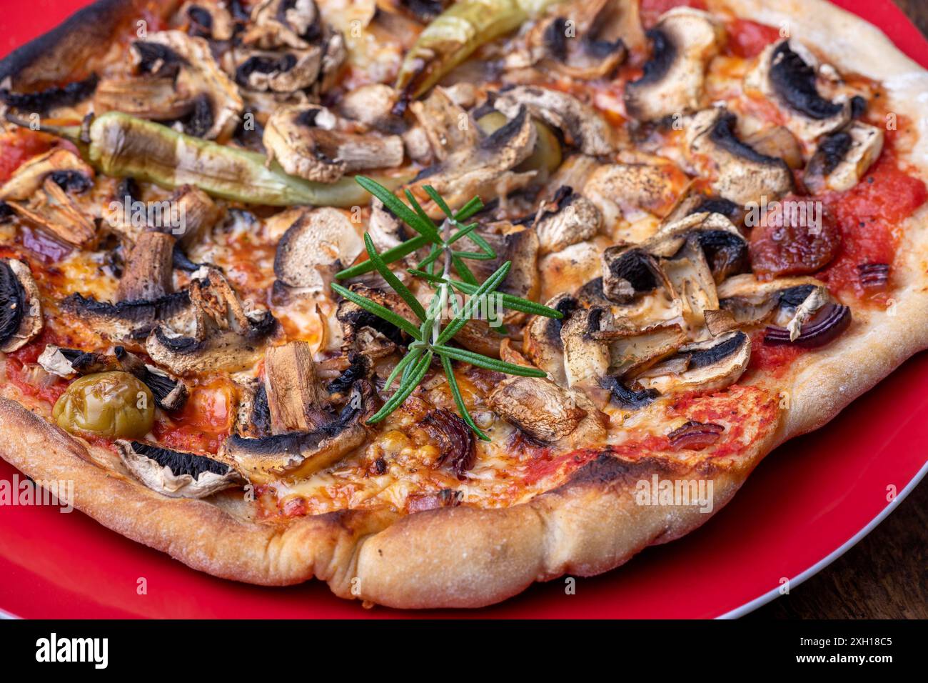 Foglia di rosmarino su una pizza Foto Stock