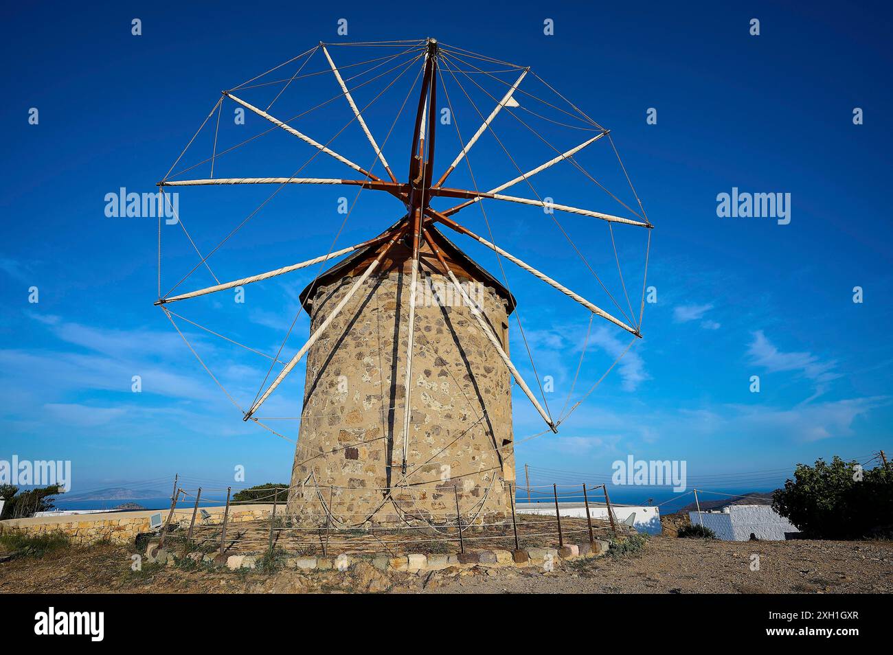 Mulino a vento in pietra con un cielo azzurro limpido sullo sfondo e un ambiente naturale, mulini a vento, su un crinale, sopra Chora, principale città di Patmos, Patmos Foto Stock