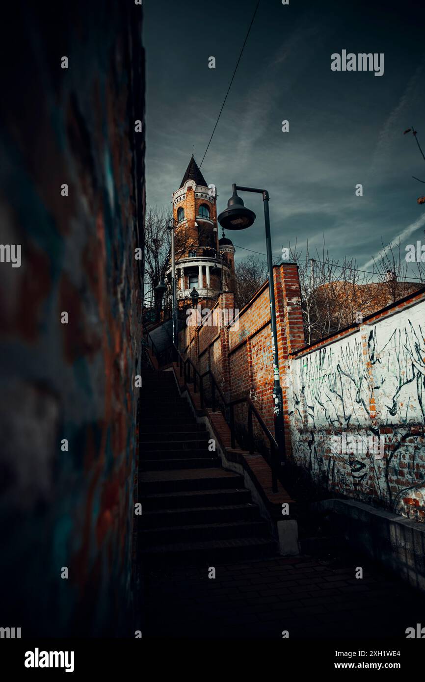 Una scala vibrante e urbana adornata da colorate opere d'arte graffiti sulla parete, che conduce verso la torre Millenium situata in cima Foto Stock