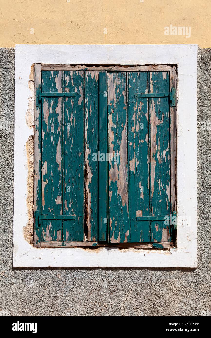 Vecchie persiane per finestre con vernice verde scheggiata per esterni Foto Stock