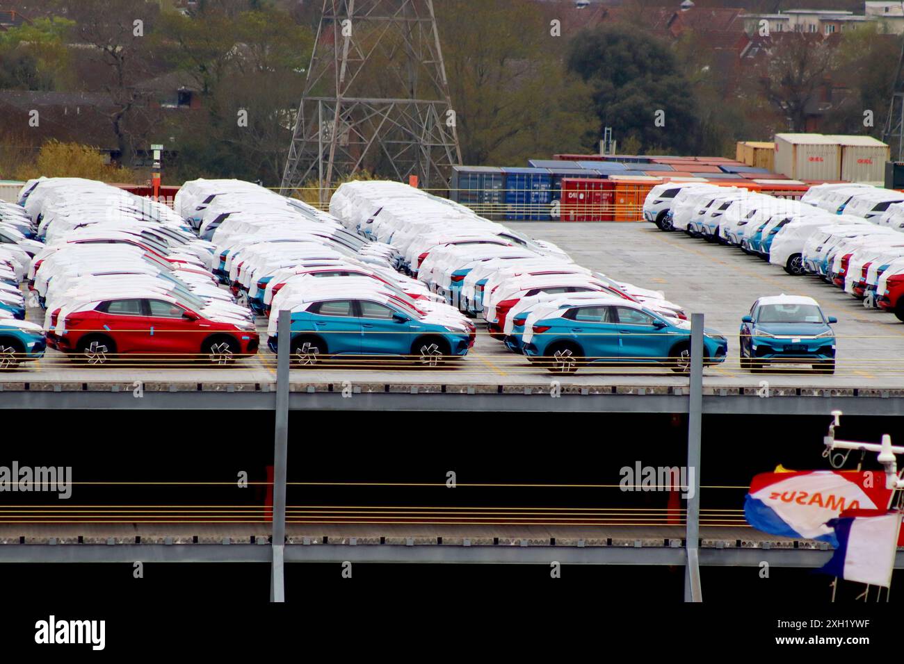 Le protezioni coprono una consegna di SUV elettrici BYD atto 3 cinesi immagazzinati in un'area di attesa della distribuzione nel Regno Unito da parte di trasportatori di automobili. Foto Stock