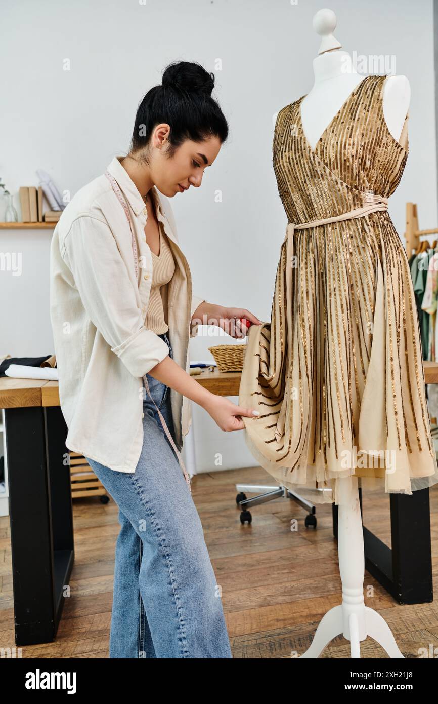 Giovane donna con un abbigliamento casual accanto al manichino che mostra un abito, realizzando una moda eco-consapevole. Foto Stock