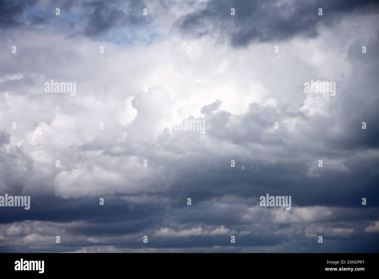 Le nuvole di tempesta nascondono scorci di cielo blu Foto Stock