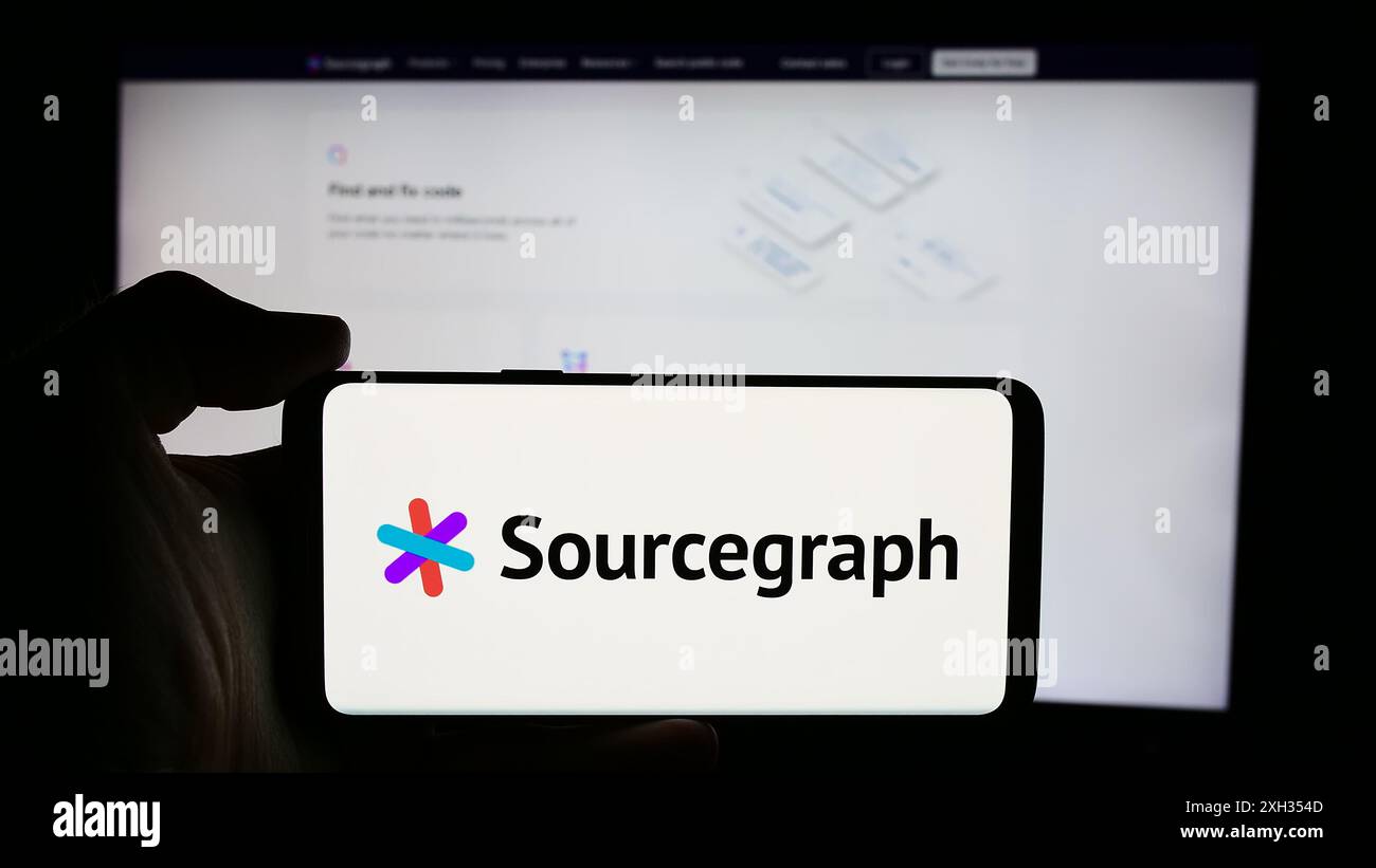 Persona che detiene un cellulare con il logo della società statunitense di intelligence in codice Sourcegraph Inc. Di fronte alla pagina Web aziendale. Mettere a fuoco il display del telefono. Foto Stock