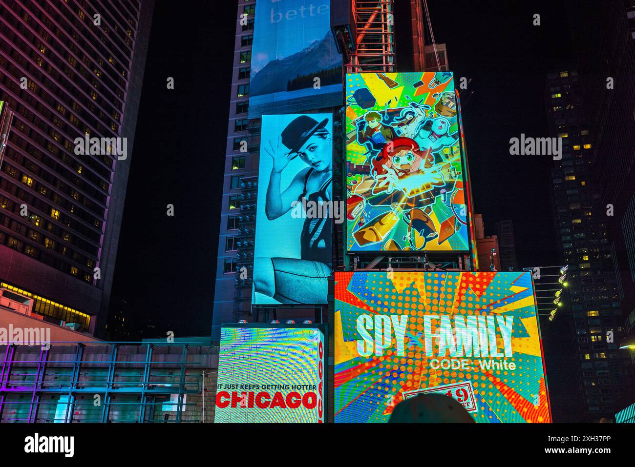 Splendida vista notturna delle facciate dei grattacieli con pannelli a LED che pubblicizzano i musical 'Chicago' e 'Spy Family' a Broadway. New York. STATI UNITI. Foto Stock