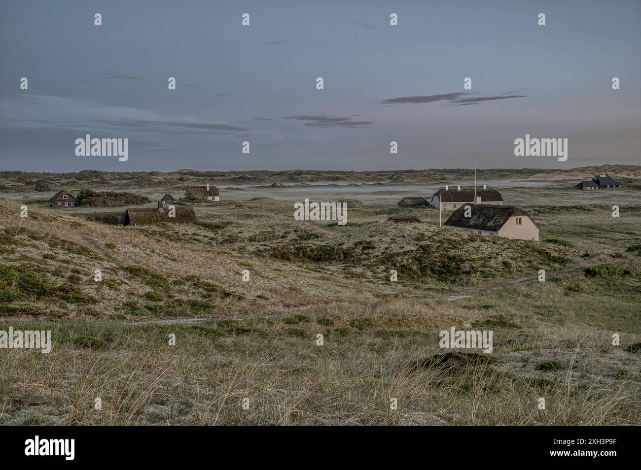 Case di paglia sparse tra le dune quando la nebbia si stabilizzò la sera, Skagen, Danimarca, 30 maggio 2024 Foto Stock