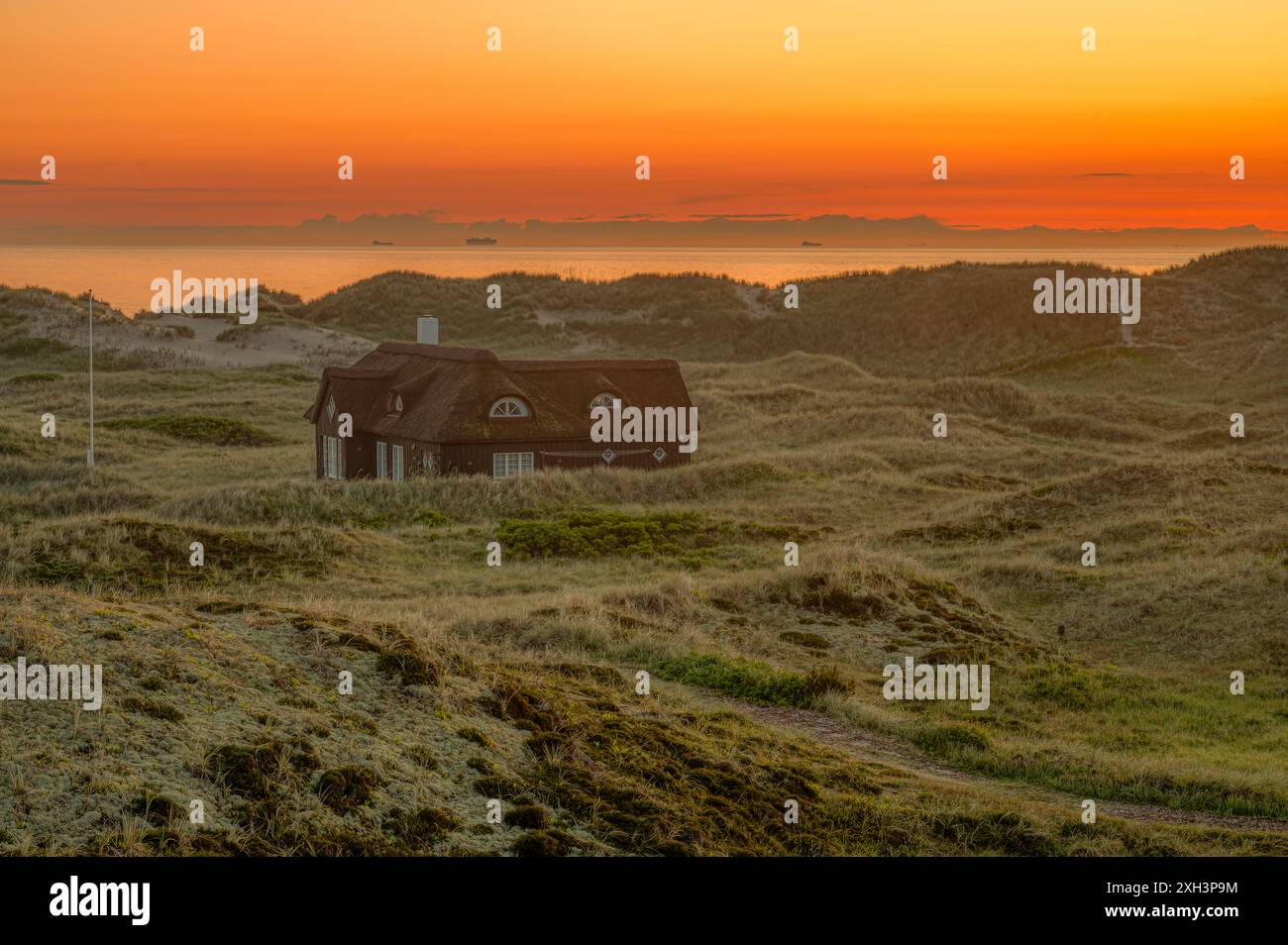 Vecchia casa solitaria di paglia tra le dune durante l'ora del crepuscolo, Skagen, Danimarca, 30 maggio 2024 Foto Stock