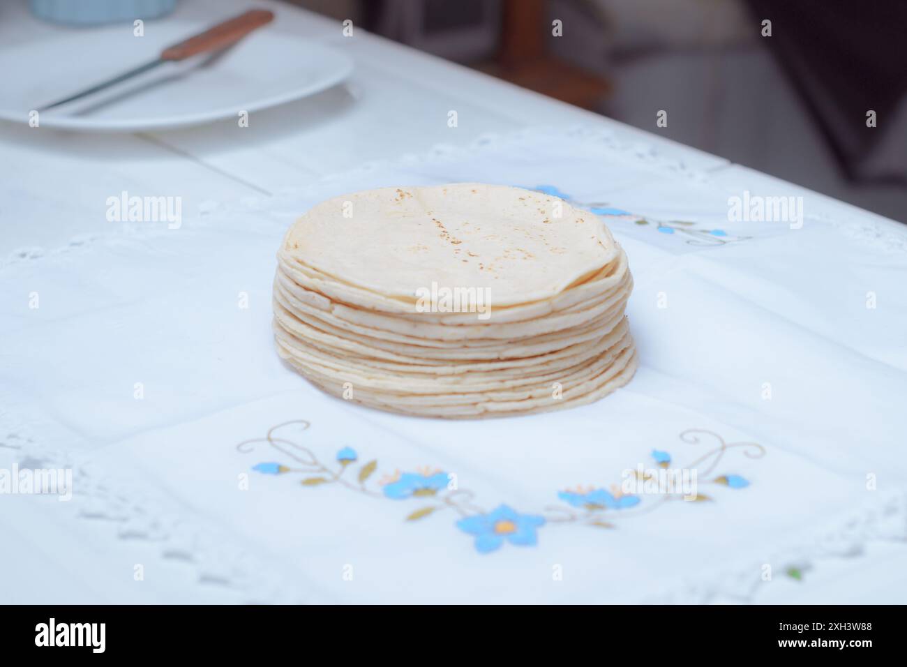 Una pila di tortillas messicane fatte in casa su un tavolo in cucina. Foto Stock