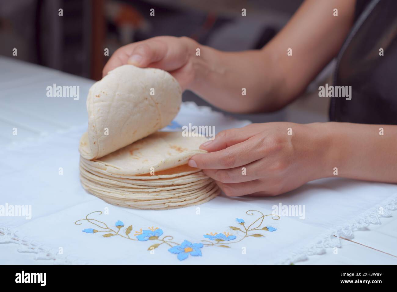 Tortillas messicane fatte in casa, tortillas con le mani femminili, chef all'interno di una cucina. Foto Stock