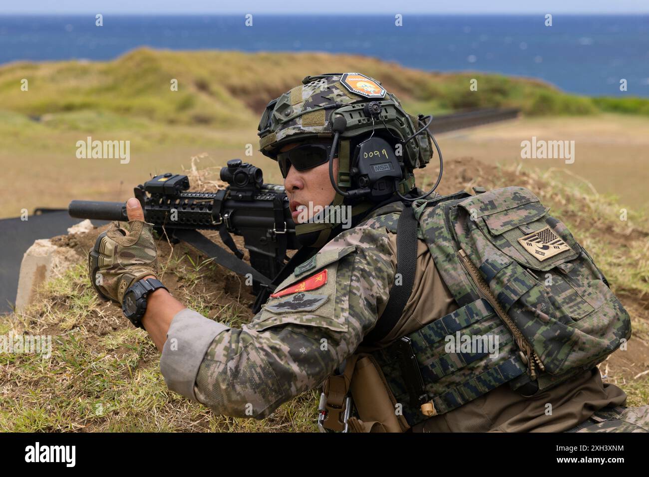 Un marine della Marina della Repubblica di Corea segnala alla sua squadra di fuoco mentre conduceva un raggio di fuoco vivo con le nazioni partner durante l'esercitazione Rim of the Pacific (RIMPAC) 2024 presso la Marine Corps base Hawaii, 10 luglio. Ventinove nazioni, 40 navi di superficie, tre sottomarini, 14 forze terrestri nazionali, più di 150 aerei e 25.000 personale partecipano al RIMPAC nelle e intorno alle isole Hawaii, dal giugno 27 al agosto 1. Il RIMPAC, la più grande esercitazione marittima internazionale al mondo, offre un'opportunità di formazione unica, promuovendo e sostenendo le relazioni di cooperazione tra i partecipanti fondamentali per l'esercizio Foto Stock