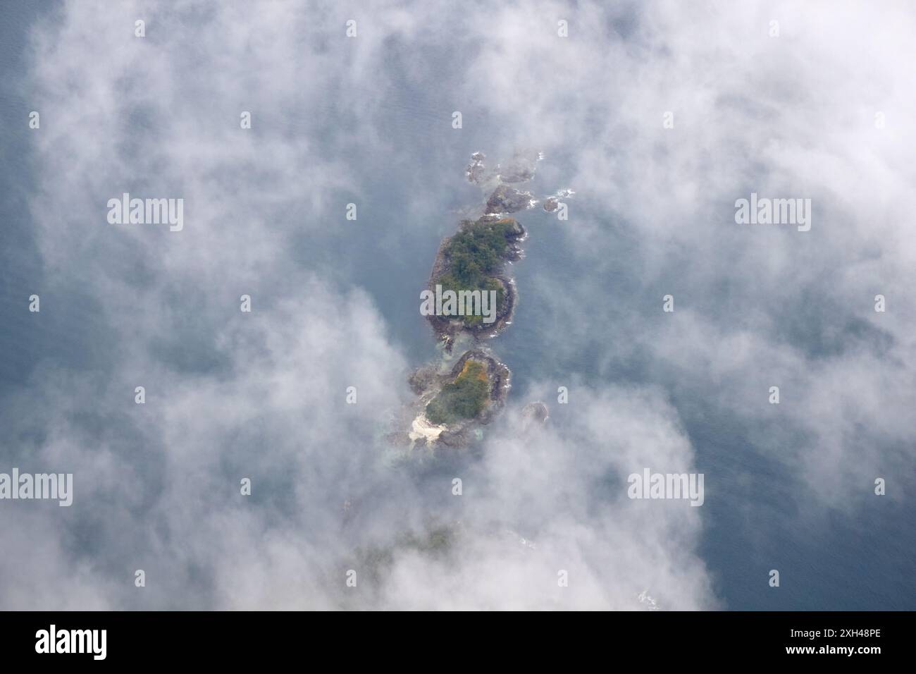 Un'isola è circondata da nuvole. Foto Stock