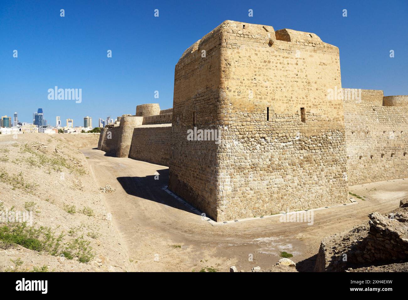 Bahrain Fort date dal 2300 BC in rame e bronzo. Una volta capitale del Dilmun civiltà. Guardando ad ovest di Manama cityscape Foto Stock