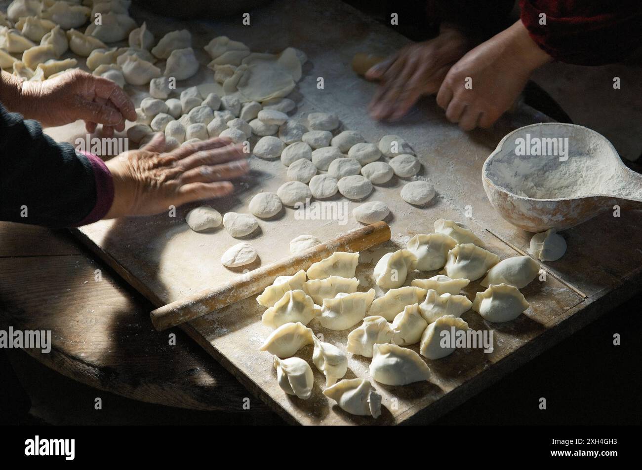 Rendendo tradizionale dim sum gnocchi Cinesi. Impasto di carne pasticceria e cipolline cucina. Cucina agriturismo provincia di Shandong, Cina Foto Stock