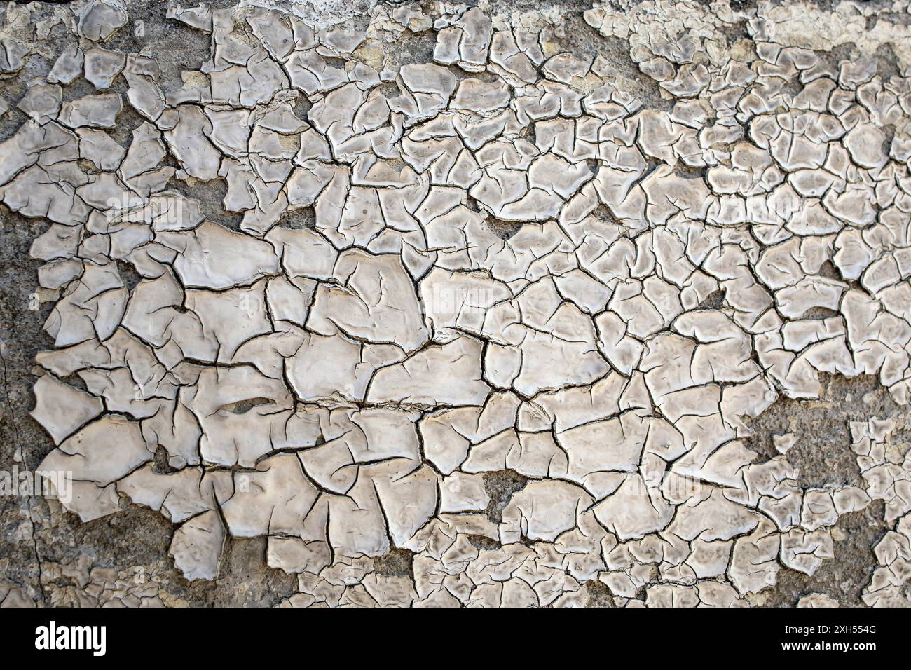 Sfondo obsoleto di una parete di cemento con sole bruciato mentre si dipinge, si stacca la trama in stucco Foto Stock