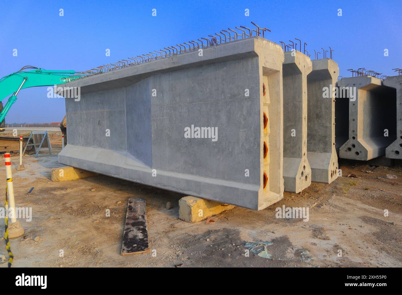 Il calcestruzzo precompresso o tre blocchi di calcestruzzo grigio sono impilati l'uno sull'altro. I blocchi si trovano in un campo e sono circondati da una macchina verde Foto Stock