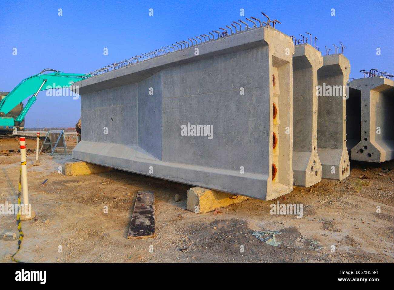 Il calcestruzzo precompresso o tre blocchi di calcestruzzo grigio sono impilati l'uno sull'altro. I blocchi si trovano in un campo e sono circondati da una macchina verde Foto Stock