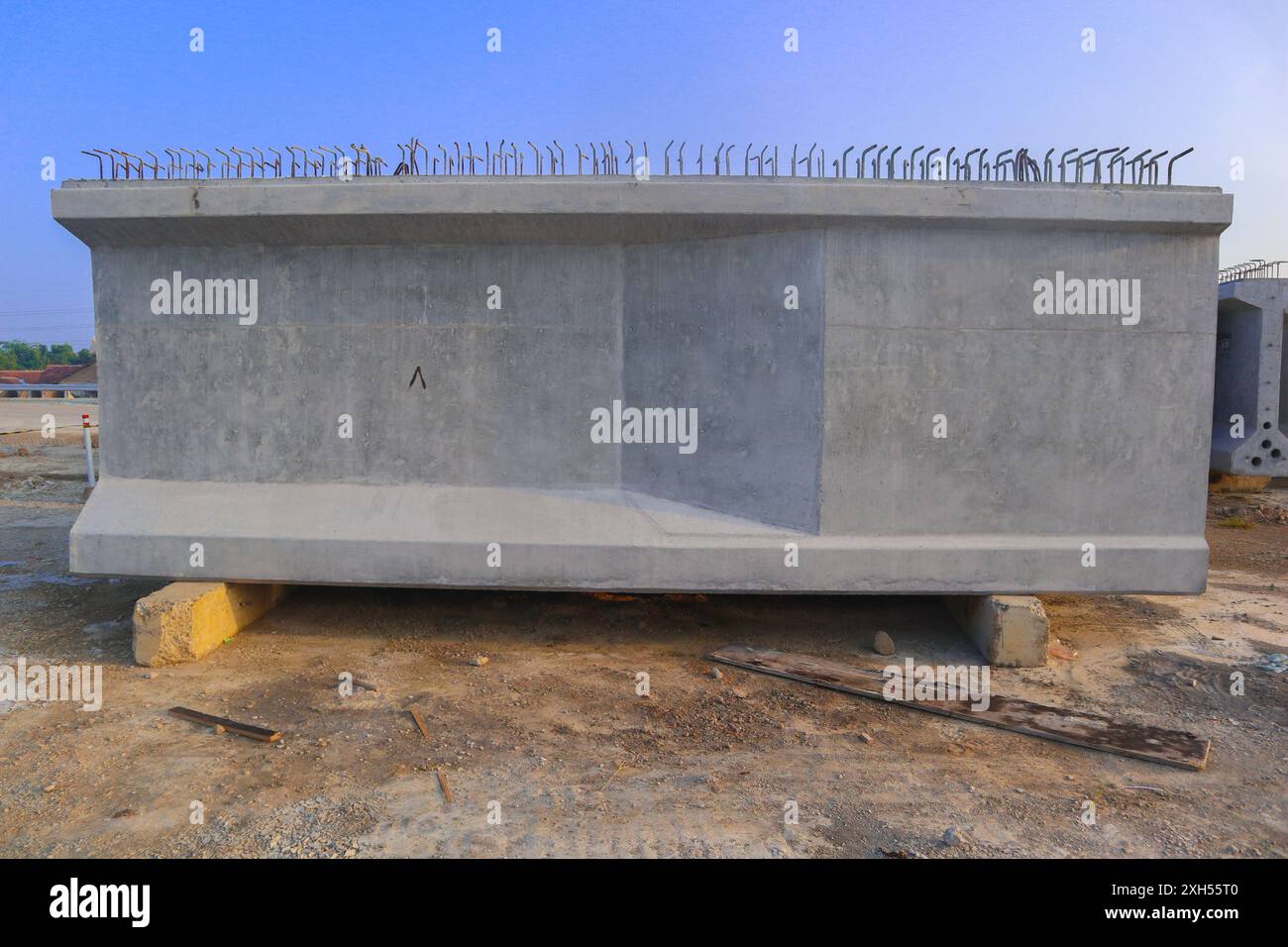 Il calcestruzzo precompresso o tre blocchi di calcestruzzo grigio sono impilati l'uno sull'altro. I blocchi si trovano in un campo e sono circondati da una macchina verde Foto Stock