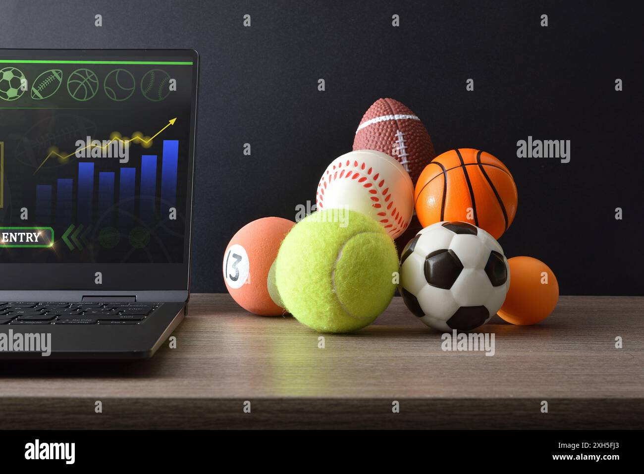 Concetto di intrattenimento con tecnologia nello sport con un computer con un'applicazione di analisi e risultati di gioco e un laptop su un tavolo da ufficio con Foto Stock