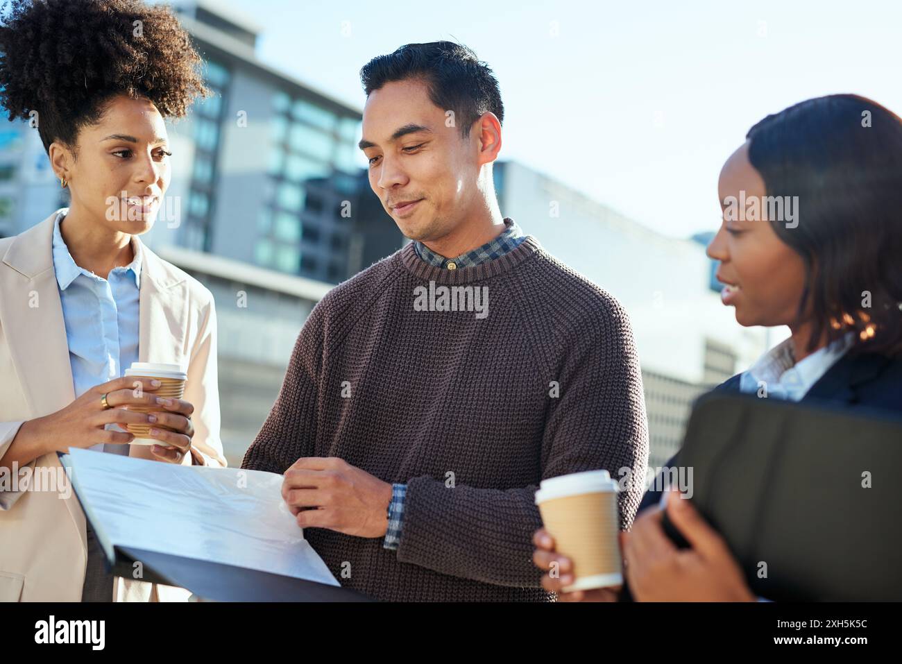 Gruppo diversificato di imprenditori urbani che discutono idee all'aperto Foto Stock