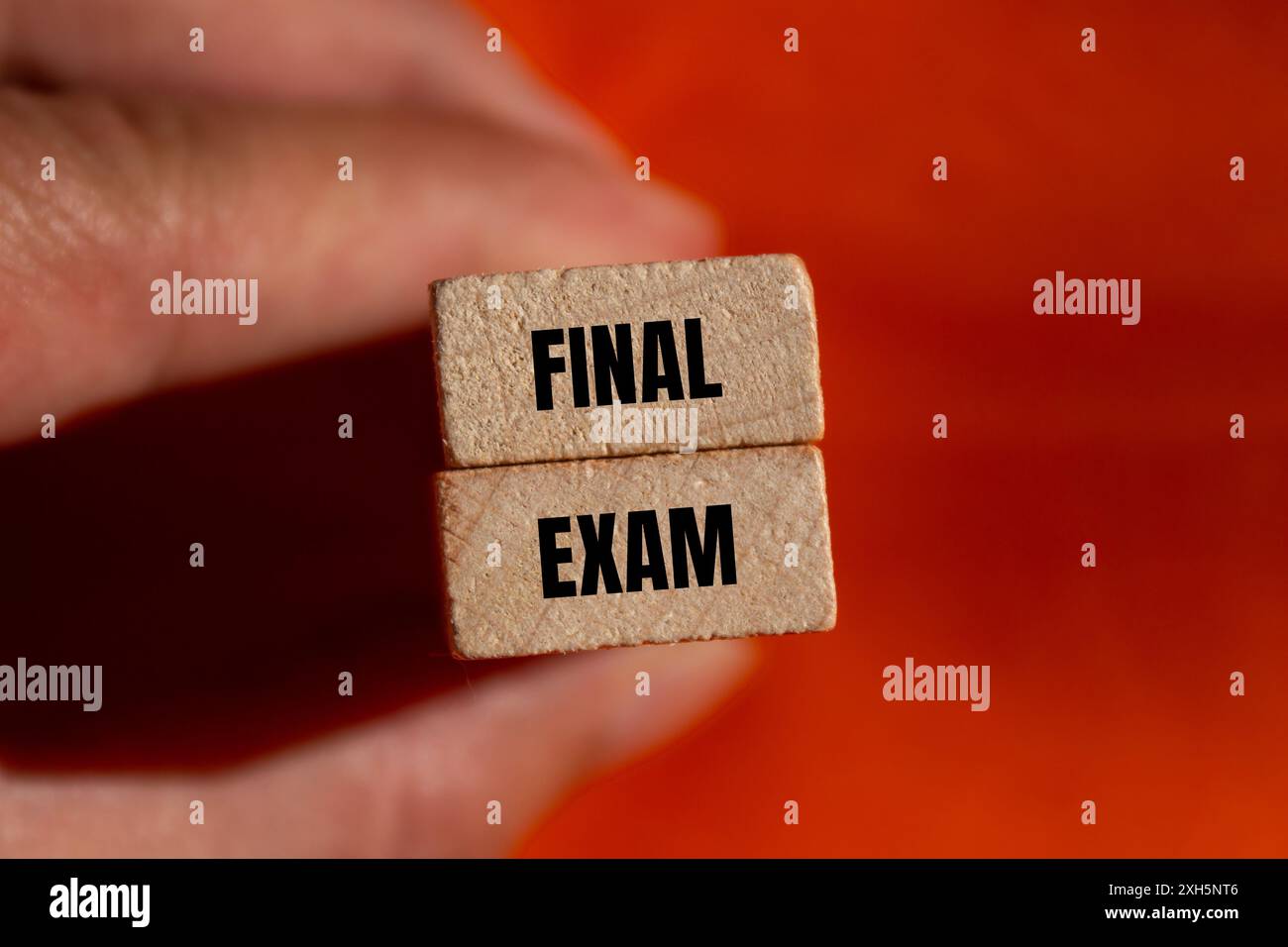 Final exam message written on wooden blocks with orange background. Conceptual final exam symbol. Copy space. Foto Stock