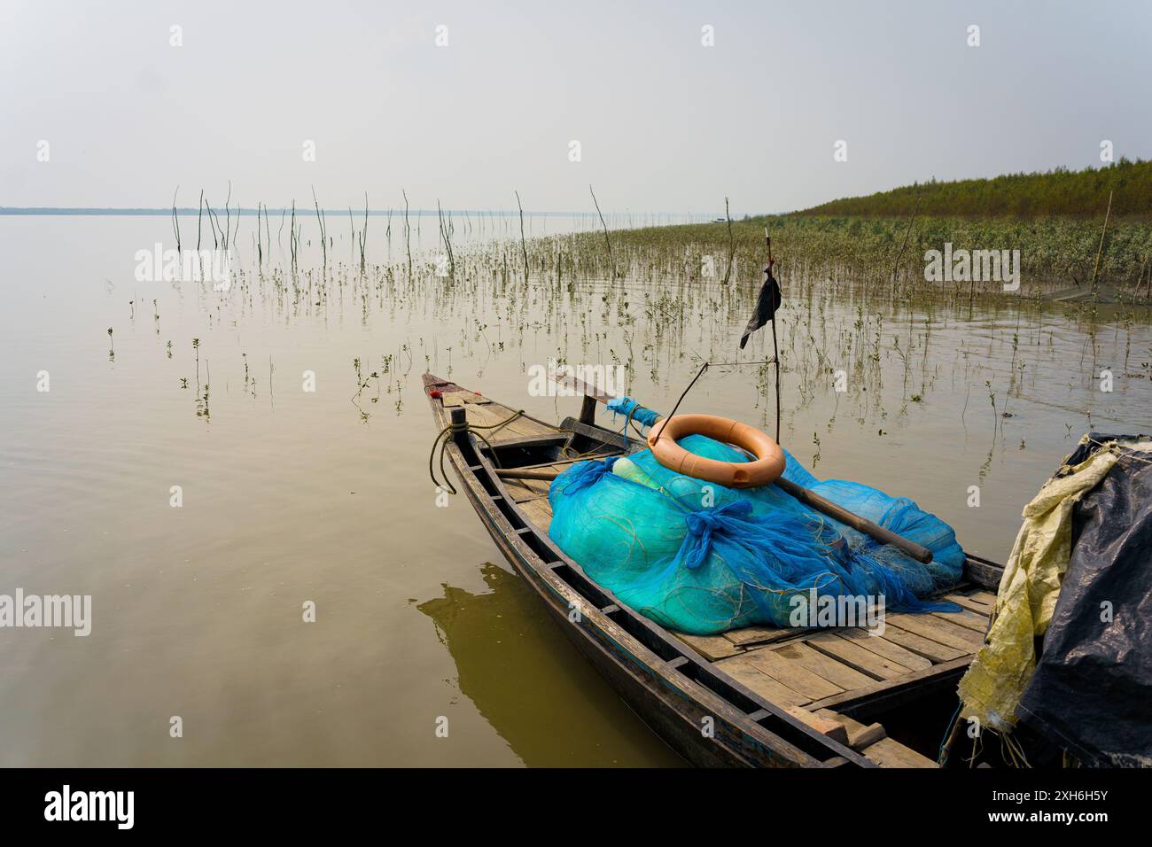 Una barca da pesca tradizionale è vista su un torrente sulla costa del delta del Sundarbans. Concetto di pesca e ambiente in Indian Sundarbans regi Foto Stock