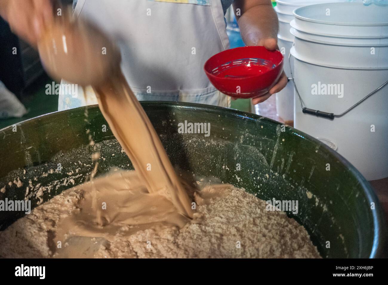 Un portabandiera del Mercado de Abastos mescola il tejate, o 'drink of the Gods, una bevanda tradizionale di Oaxacan a base di mais, fagioli di cacao e fiori. Foto Stock