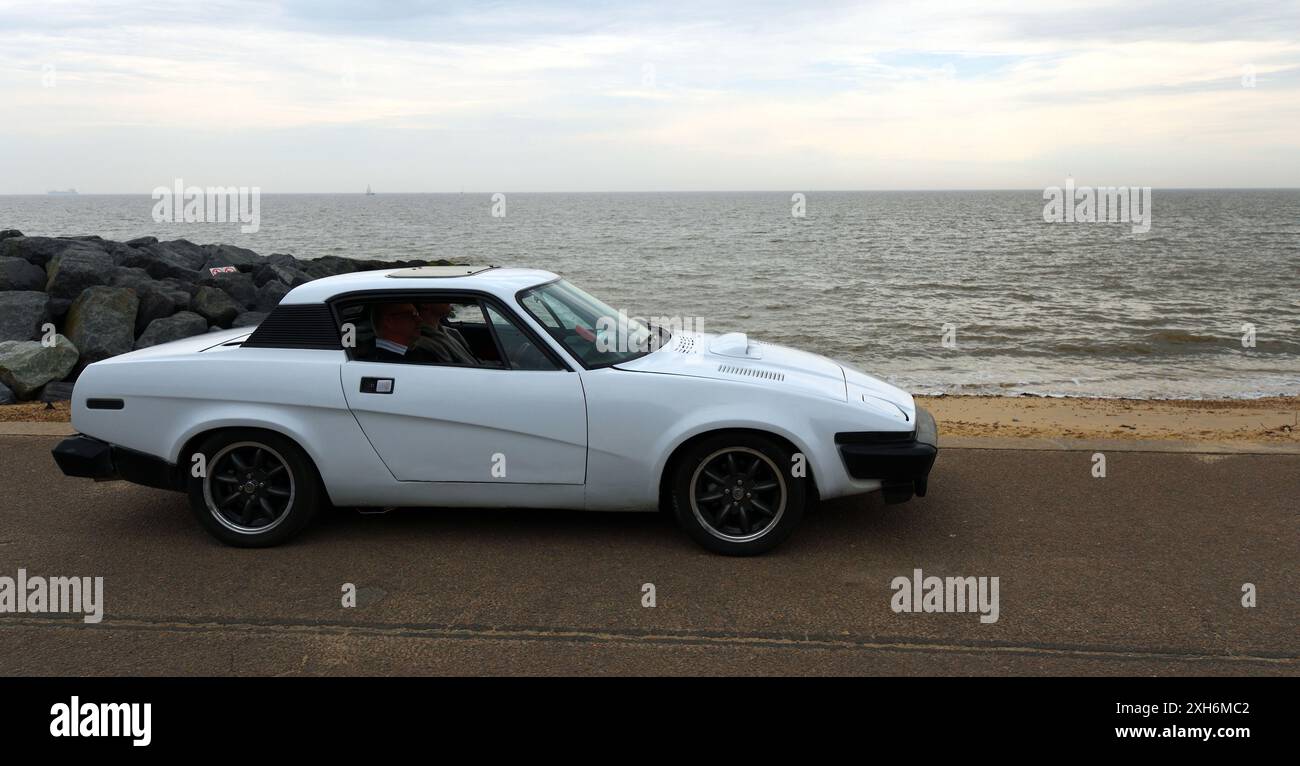 Auto Triumph TR7 classica parcheggiata sul lungomare e sul mare sullo sfondo. Foto Stock