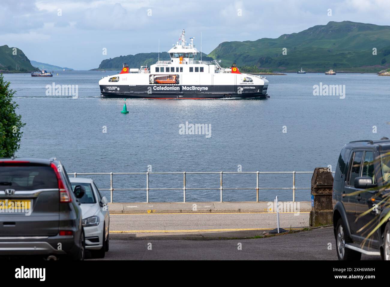 Un traghetto 'Cal Mac' passa oltre la Coran Esplanade Road a Oban, in Scozia. Foto Stock