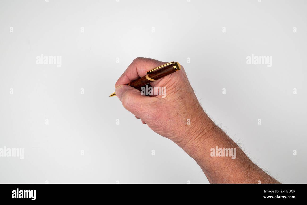 Uomo caucasico che tiene a mano la penna a sfera con involucro in legno su sfondo bianco Foto Stock