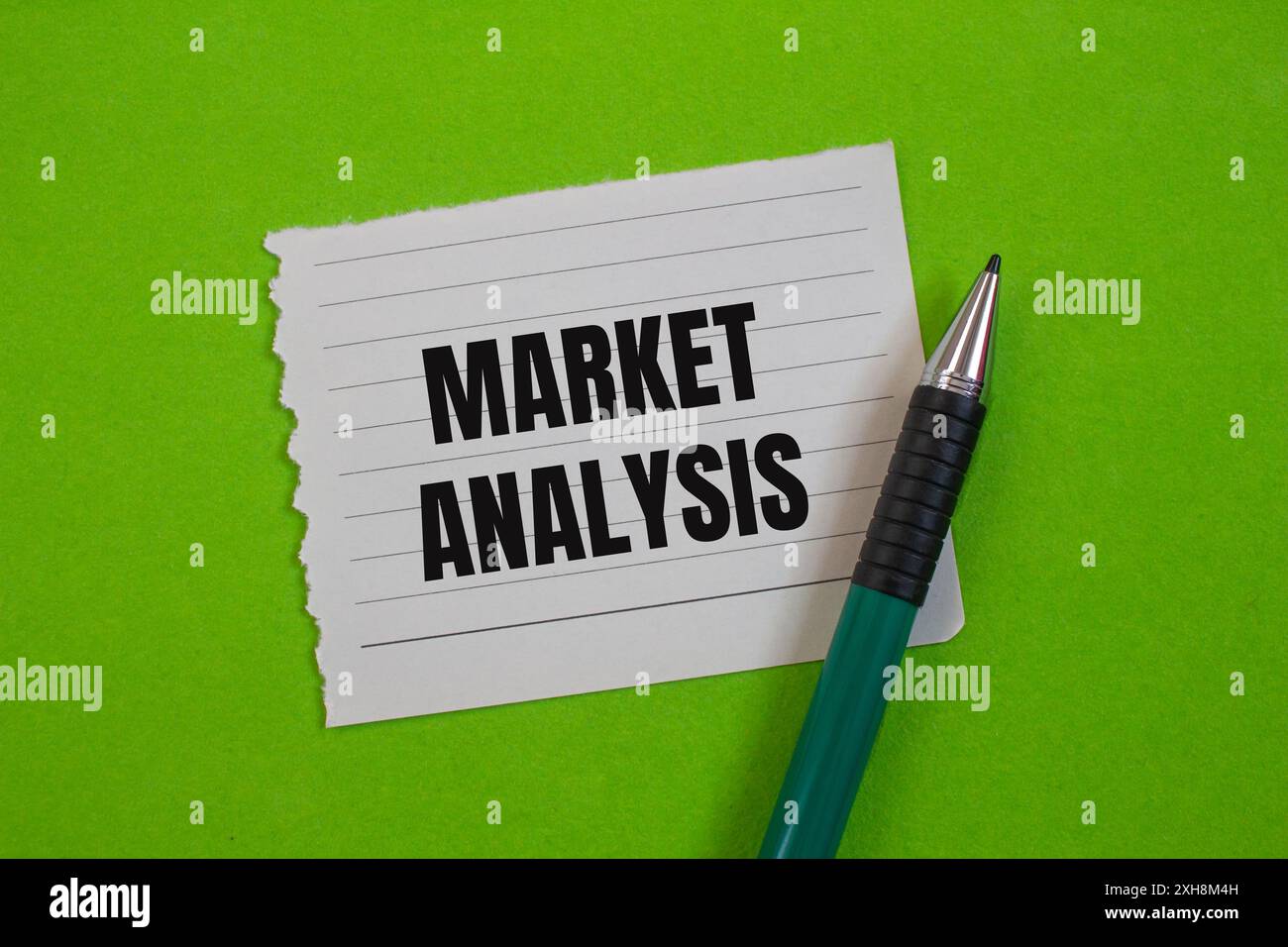 Messaggio di analisi di mercato scritto su carta strappata con sfondo verde. Simbolo dell'analisi concettuale di mercato. Copia spazio. Foto Stock