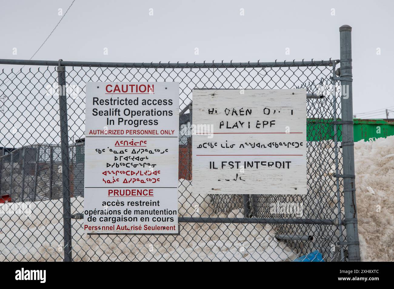 Cartello di avvertimento multilingue in inglese, francese e inuktitut a Iqaluit, Nunavut, Canada Foto Stock