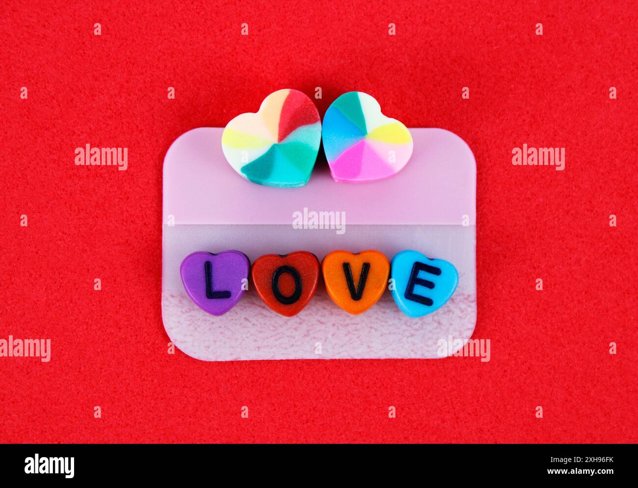 Un paio di cuori colorati e parole d'amore su una nota adesiva Foto Stock