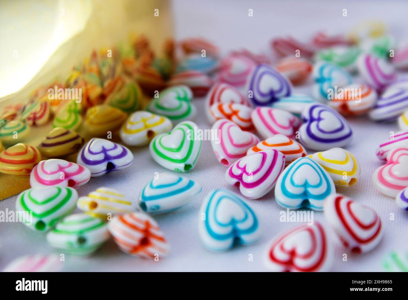 Gruppo di cuori colorati riflessi su una superficie dorata Foto Stock