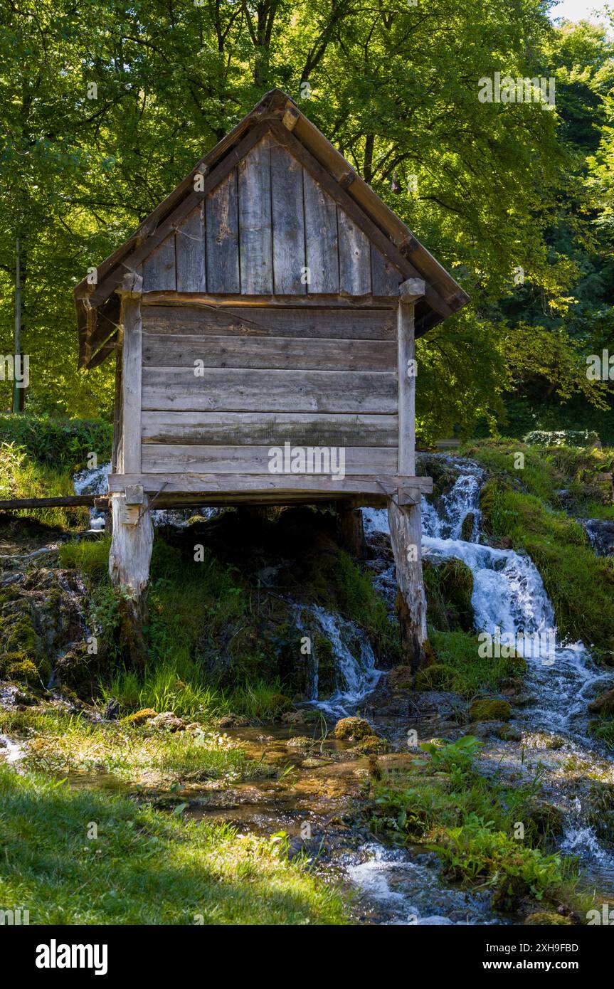 C'è un mulino molto vecchio su un piccolo ruscello. Foto Stock