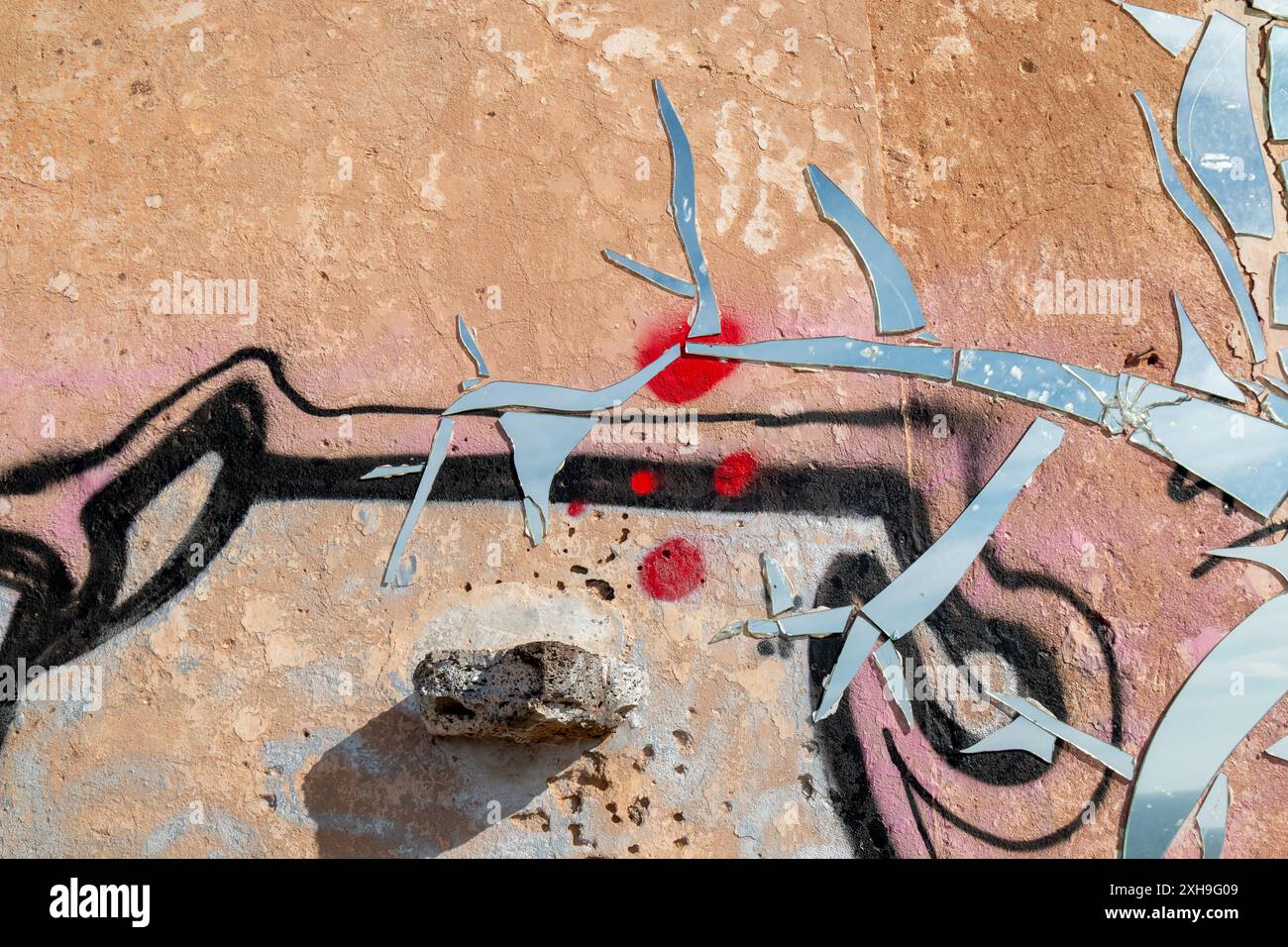 Edificio semplice abbandonato. Parete esterna coperta da graffiti e mosaico fatto di pezzi di specchio. Lanzarote, Isole Canarie, Spagna. Foto Stock