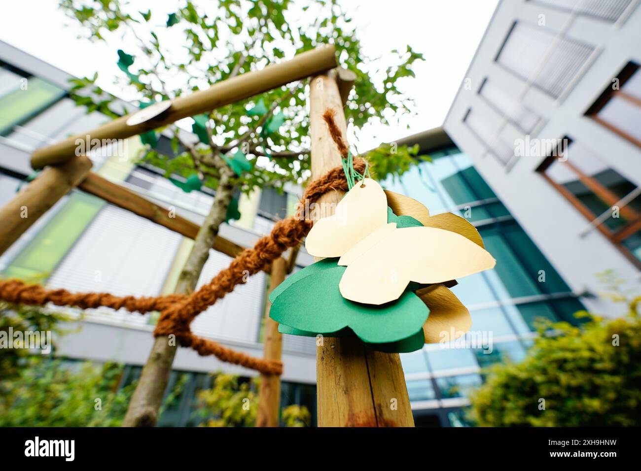 St. Leon Rot, Germania. 12 luglio 2024. Le farfalle di carta sono appese a un albero commemorativo della scuola superiore di Löwenrot. Il processo contro un diciottenne che avrebbe pugnalato a morte il suo compagno di classe della stessa età inizia il martedì (16.07.). Credito: Uwe Anspach/dpa/Alamy Live News Foto Stock