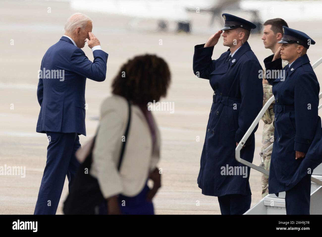 Joint base Andrews, Stati Uniti. 12 luglio 2024. Il presidente DEGLI STATI UNITI Joe Biden (L) saluta aviatori della United States Air Force, dietro il segretario stampa della Casa Bianca Karine Jean-Pierre (C), come Consiglio di amministrazione dell'Air Force One presso Joint base Andrews, Maryland, USA, 12 luglio 2024. Biden viaggia per un evento della campagna elettorale a Detroit, Michigan. Crediti: SIPA USA/Alamy Live News Foto Stock