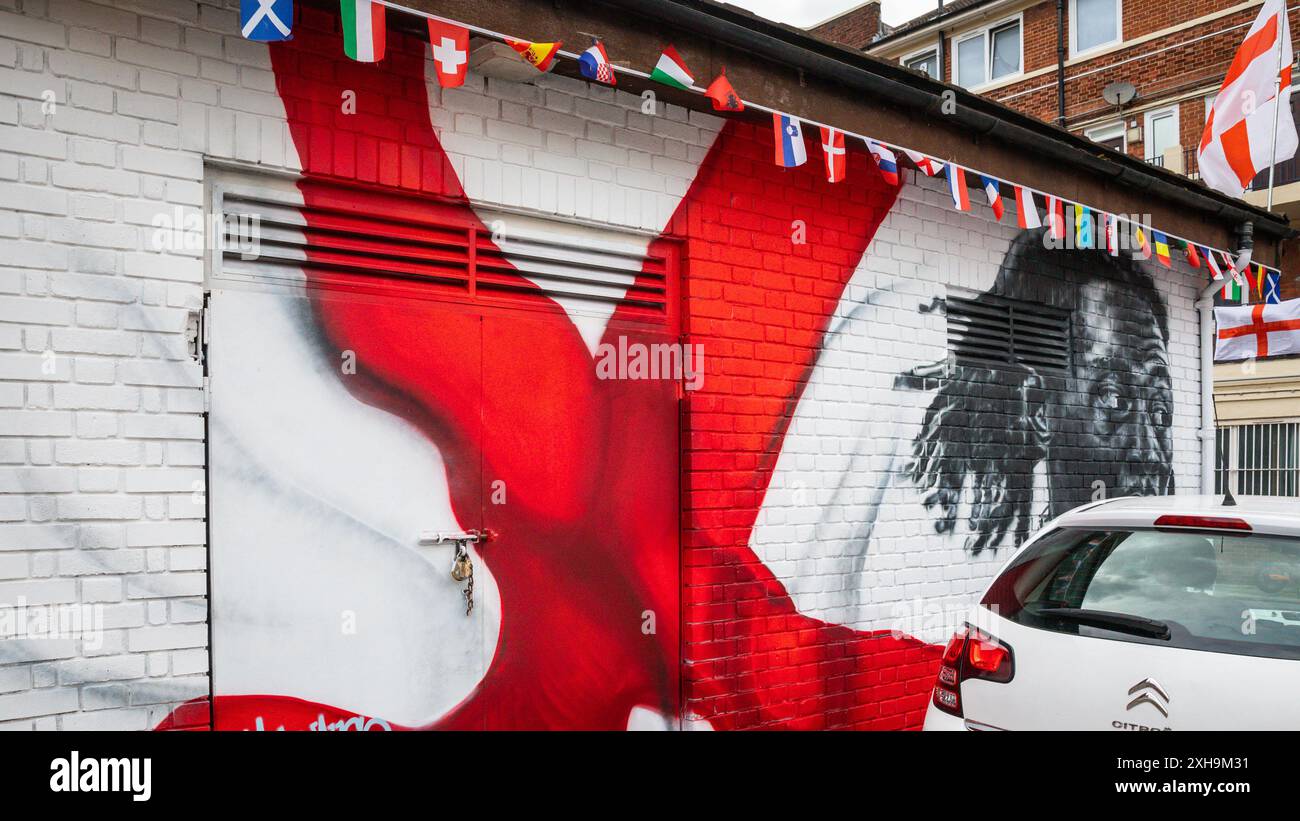 Bermondsey, Londra, 12 luglio 2024. La tenuta Kirby di Bermondsey, nota per le sue colorate bandiere per le partite di calcio dell'Inghilterra, è ancora una volta decorata con diverse centinaia di bandiere in tutta la tenuta patriottica, così come il murale recentemente inaugurato di Eberechi Eze e altri pittoreschi murales nei grouds, in vista della finale di domenica tra Inghilterra e Spagna dei Campionati europei di calcio. Crediti: Imageplotter/Alamy Live News Foto Stock