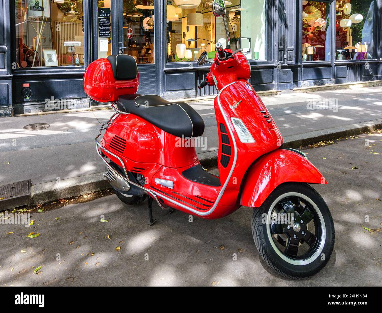 Vespa rossa parcheggiata sul Boulevard Raspail, Parigi 75014, Francia. Foto Stock