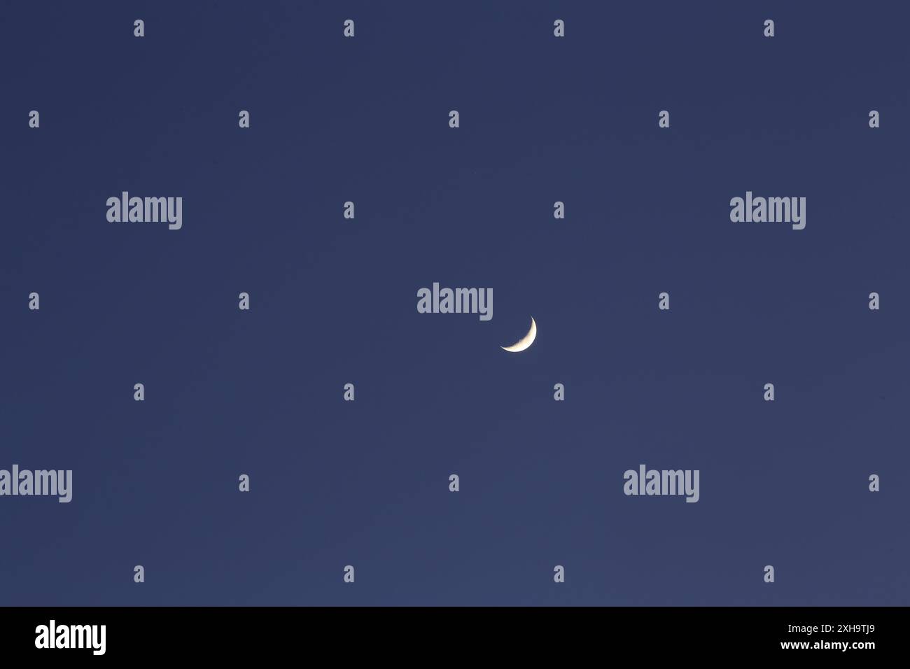 Splendida luna crescente in un cielo notturno limpido, che cattura l'essenza del tramonto. Foto Stock