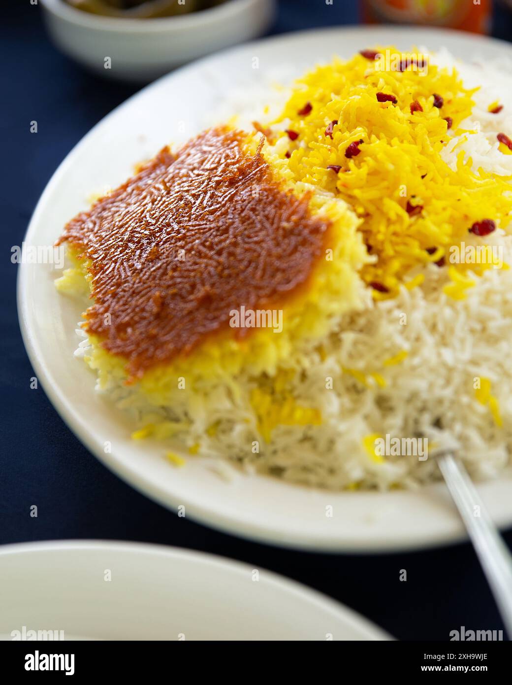 Autentico Tahdig persiano con crosta dorata croccante e riso allo zafferano, una prelibatezza tradizionale iraniana. Foto Stock